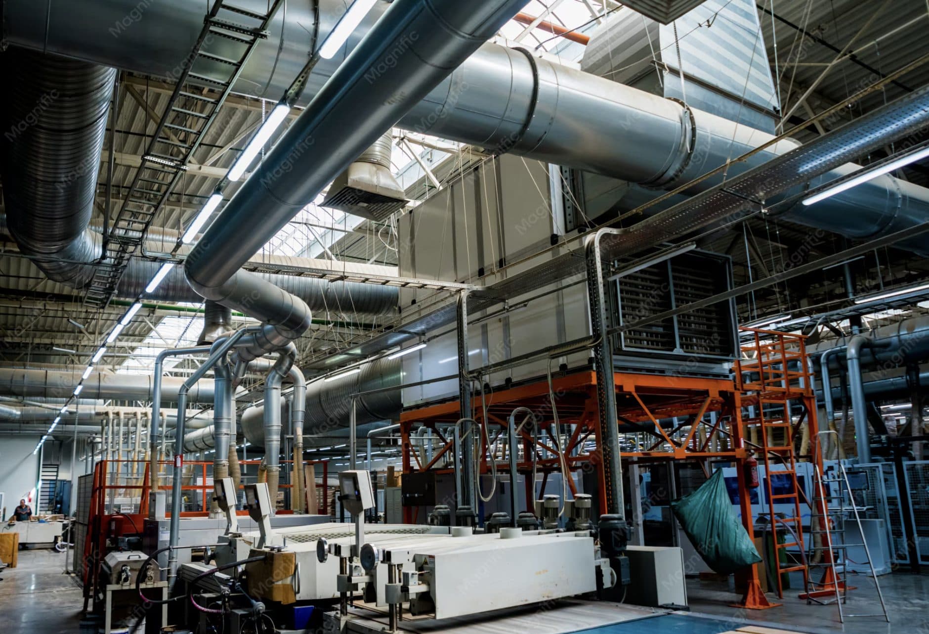 Industriel produktionshal med ventilationskanaler i loftet og forarbejdningsmaskiner